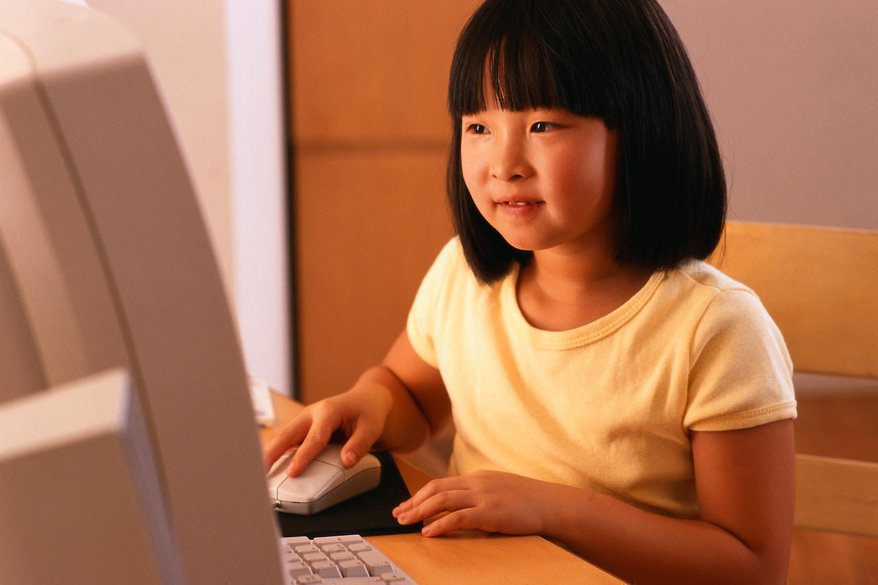 girl sitting at desk using computer